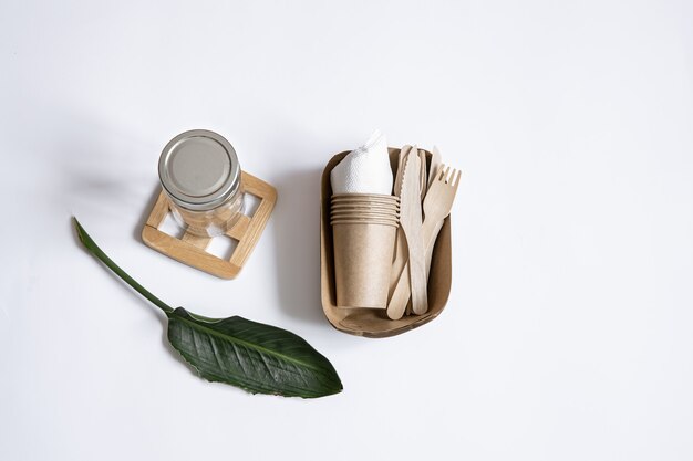 Messen, vorken, schalen, glazen pot, papieren bakjes voor voedsel en natuurlijke bladeren. Het concept van nul afval en plasticvrij.