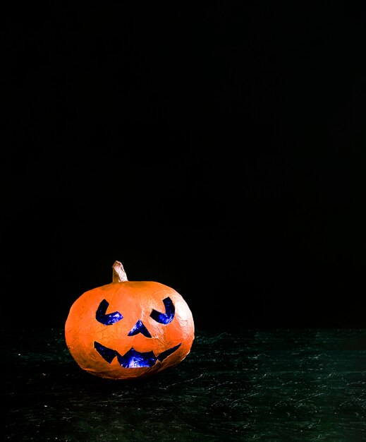 Met de hand gemaakte oranje pompoen in Halloween-stijl met boos gesneden binnen verlicht gezicht