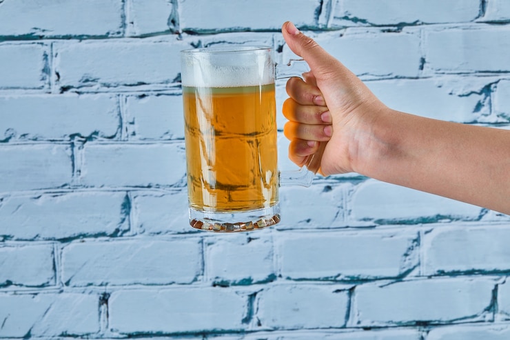 Gratis Foto met een glas bier op een blauwe achtergrond.