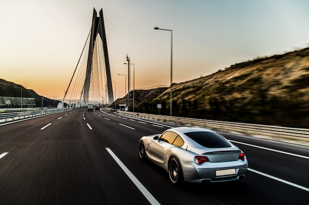 Gratis foto metaalkleursportwagen op de brug.