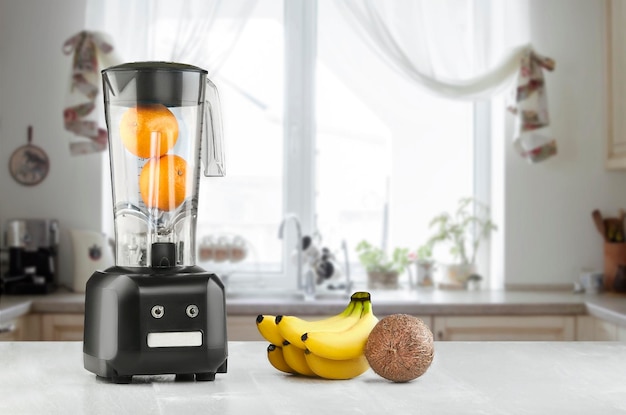 Gratis foto metal food blender close-up met verse exotische tropische vruchten ernaast op keuken achtergrond met lege ruimte. blender en houten tafel in de keuken. zonnevlam