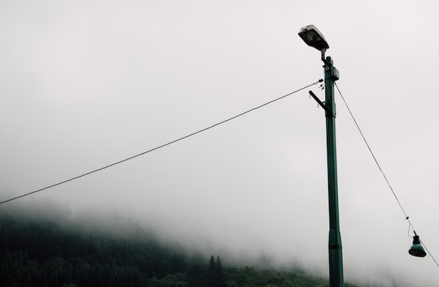 Metalen lantaarnpaal op het platteland tijdens een mistige sombere dag