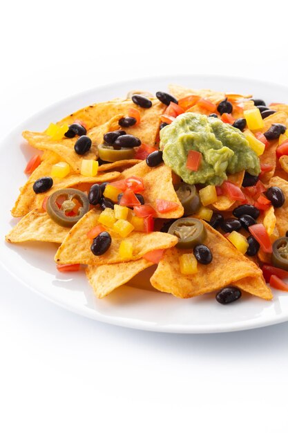 Gratis foto mexicaanse nachos tortillachips met zwarte bonen, guacamole, tomaat en jalapeno geïsoleerd op een witte achtergrond