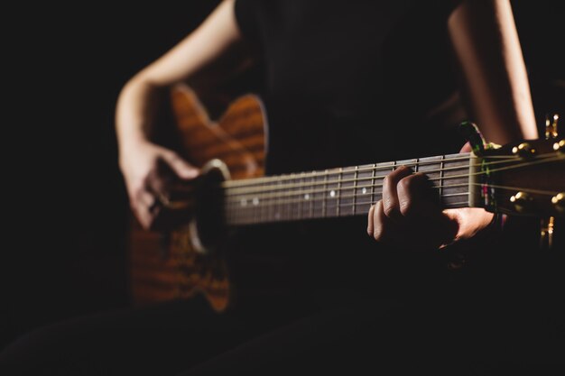 Mid-section vrouwelijke student gitaar spelen