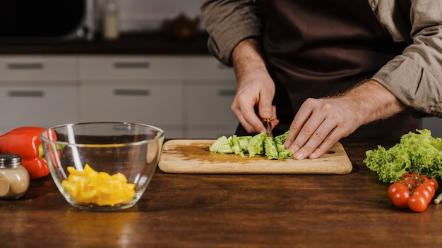 Mid shot chef-kok snijden salade