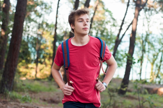 Mid shot jongen met rugzak in bos