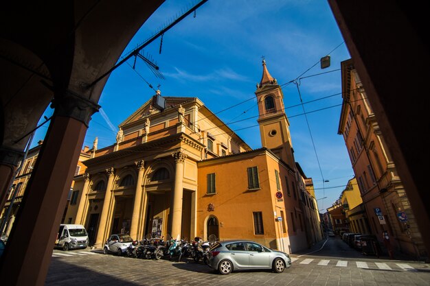 Middeleeuwse straatportiek met felgekleurde huizen in de oude stad in de zonnige dag, Bologna, Emilia-Romagna, Italië