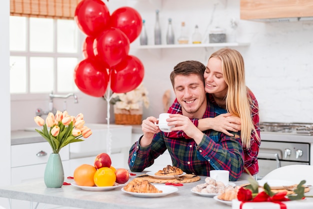 Gratis foto middelgroot geschoten gelukkig paar met ontbijt in de keuken