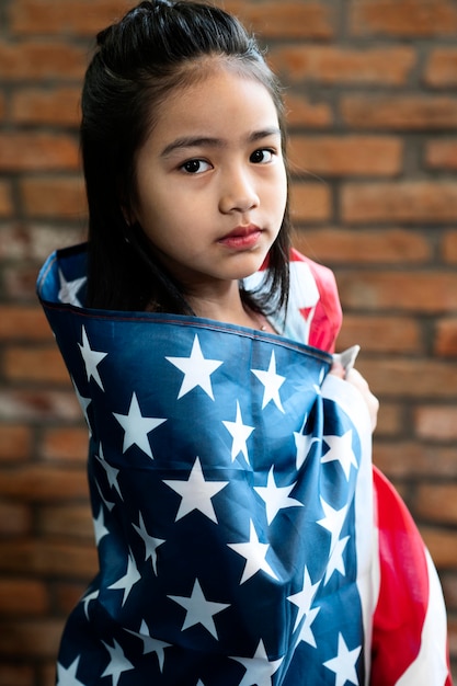 Middelgroot geschoten meisje dat Amerikaanse vlag houdt