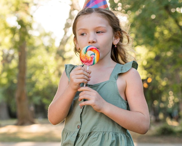 Middelgroot geschoten meisje dat lolly eet