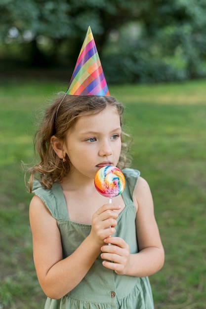 Middelgroot geschoten schattig meisje dat lolly eet