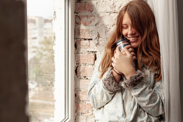 Gratis foto middelgroot schot gelukkig meisje met fles