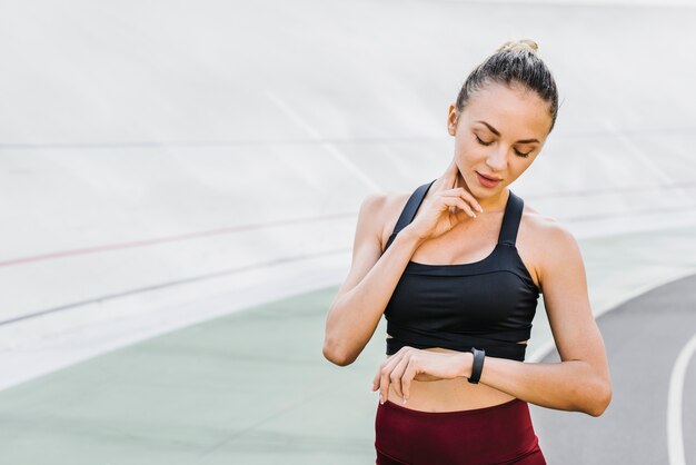 Middelgroot schot van atleet die haar horloge controleert