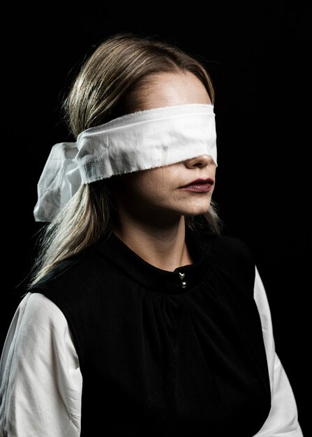 Middelgroot schot van vrouw die witte blinddoek draagt