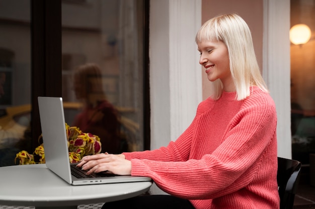 Middelgrote albinovrouw die met laptop werkt