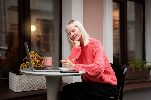 Middelgrote albinovrouw die met laptop werkt