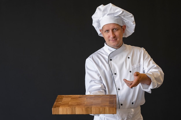 Middelgrote geschoten chef-kok die houten raad houdt