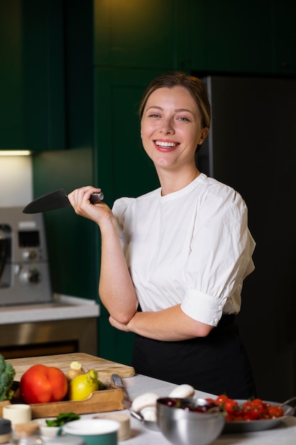 Middelgrote geschoten smileyvrouw in keuken