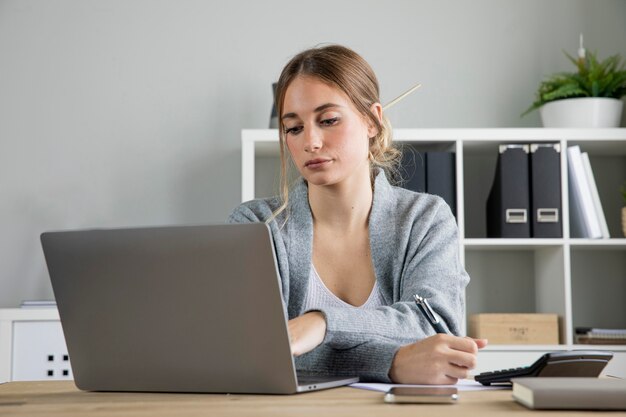 Middelgrote geschoten vrouw die aan laptop werkt
