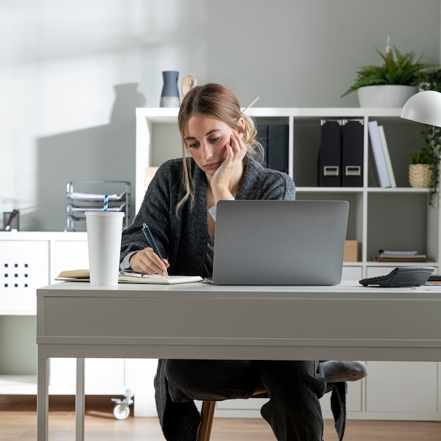 Middelgrote geschoten vrouw die bij bureau werkt