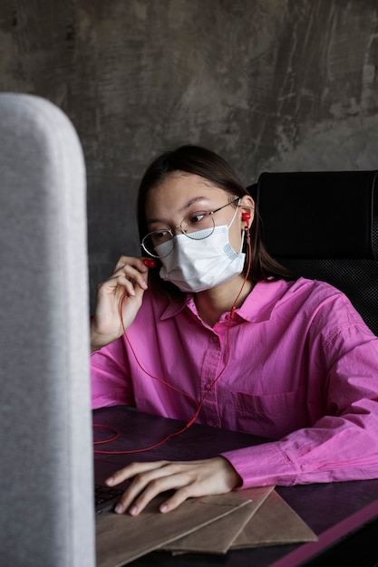 Middelgrote geschoten vrouw die gezichtsmasker draagt