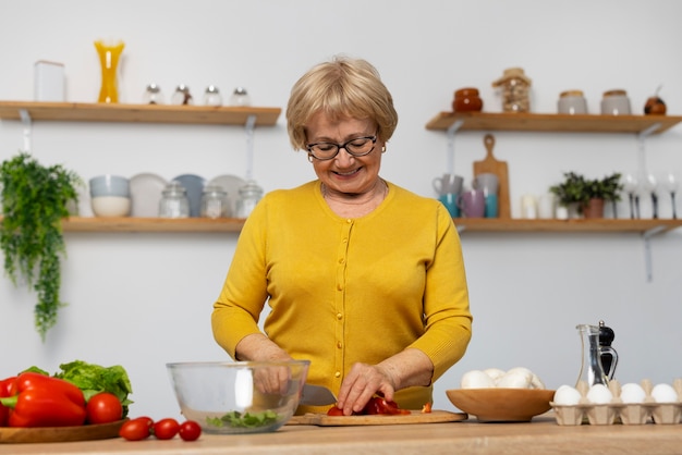 Gratis foto middelgrote geschoten vrouw die in keuken kookt