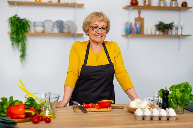 Gratis foto middelgrote geschoten vrouw die in keuken kookt