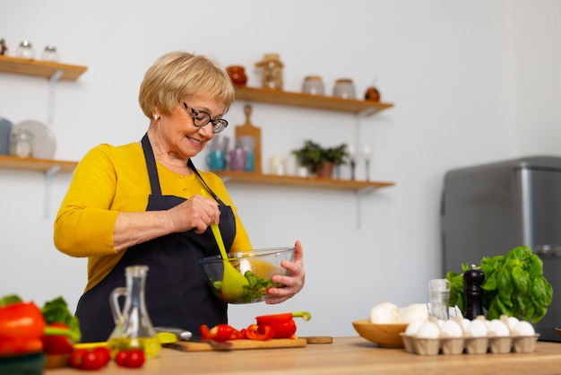 Gratis foto middelgrote geschoten vrouw die in keuken kookt