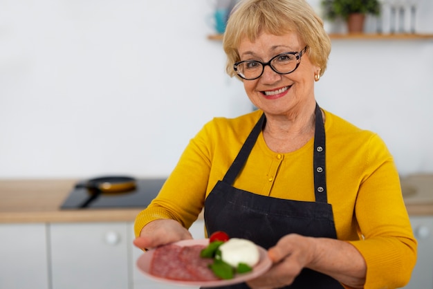 Gratis foto middelgrote geschoten vrouw die in keuken kookt