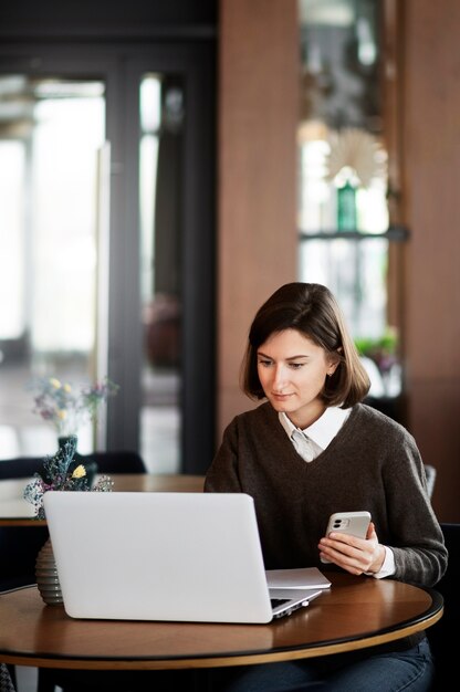 Middelgrote geschoten vrouw die met laptop werkt