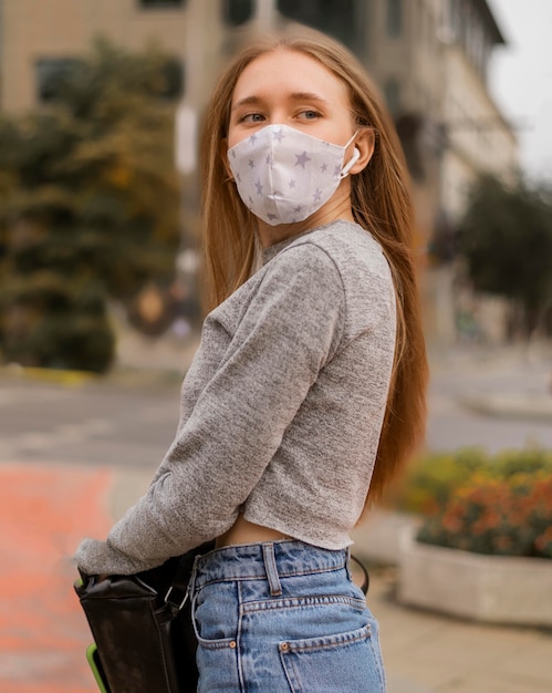 Middelgrote geschoten vrouw met medisch masker