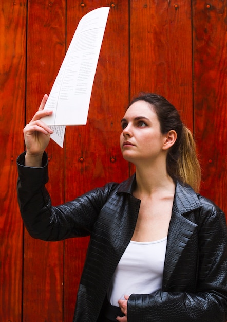 Middelgrote geschotene vrouw die een document leest