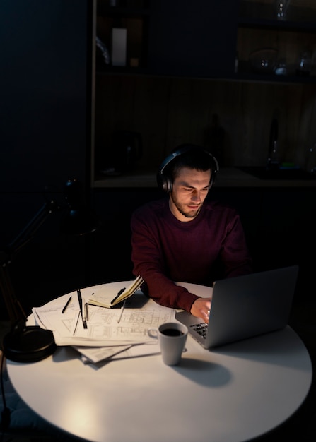 Middelgrote man aan het werk 's avonds laat op laptop