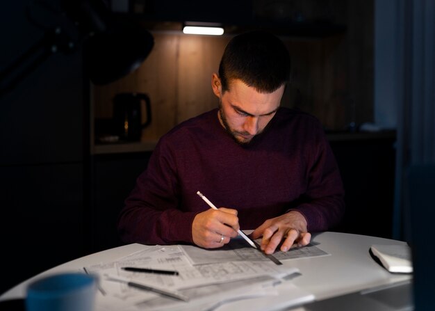 Middelgrote man aan het werk 's avonds laat op laptop