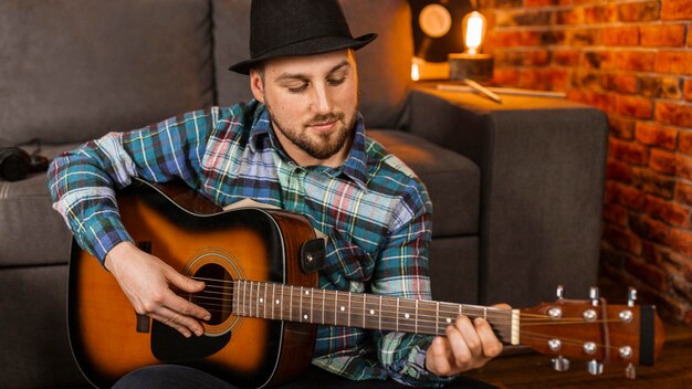 Middelgrote man die gitaar speelt