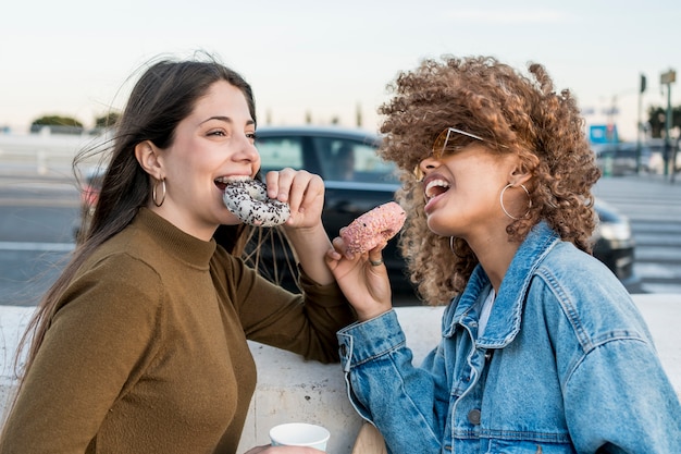 Gratis foto middelgrote vrienden die donuts eten