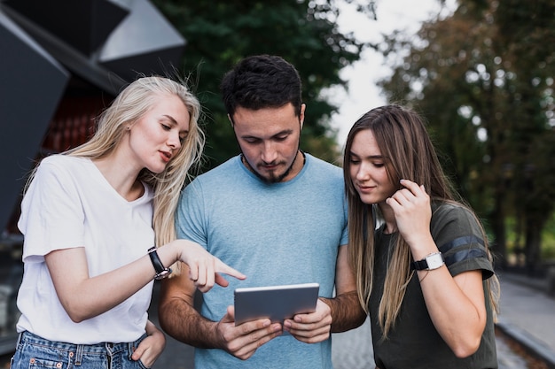 Middelgrote vrienden die op een tablet kijken