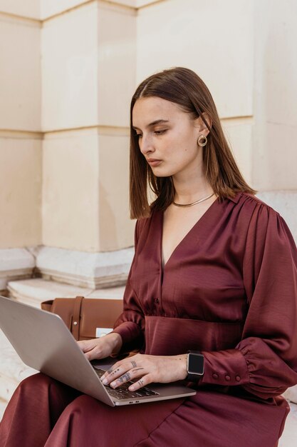 Middelgrote vrouw die aan een laptop werkt.