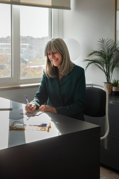 Middelgrote vrouw die op kantoor werkt.