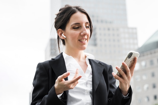 Middellange geschoten bedrijfsvrouw met airpods