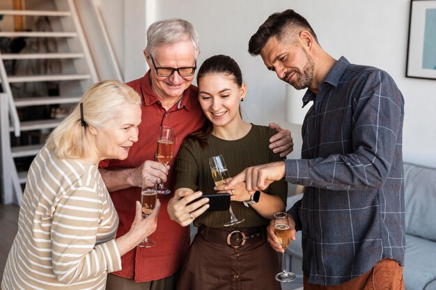 Gratis foto middellange geschoten gelukkige familie die telefoon bekijkt