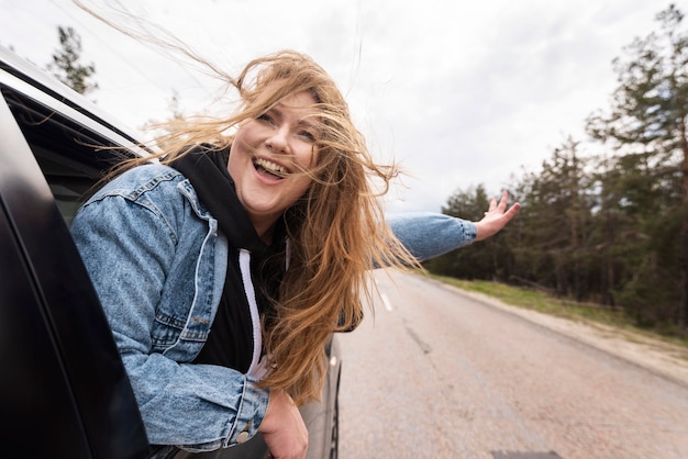 Middellange geschoten gelukkige vrouw in auto