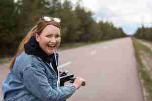 Gratis foto middellange geschoten gelukkige vrouw met autoped