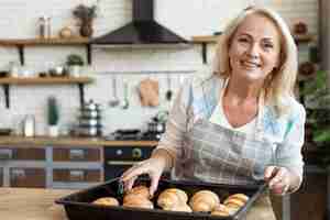 Gratis foto middellange geschoten gelukkige vrouw met croissants