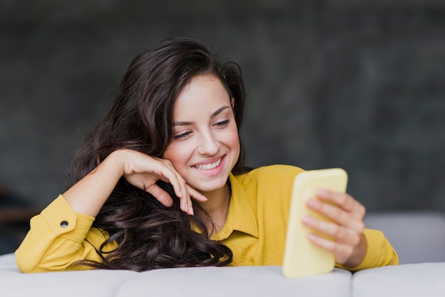 Middellange geschoten gelukkige vrouw met mobiele telefoon