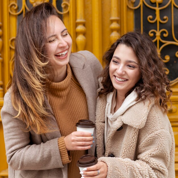 Middellange geschoten gelukkige vrouwen met koffie