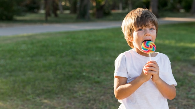 Middellange geschoten jongen die lolly eet