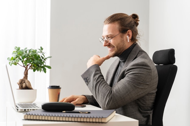 Middellange geschoten man aan bureau