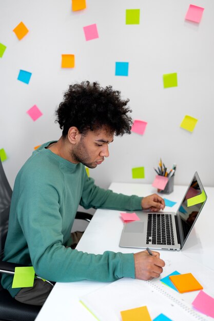 Middellange geschoten man aan het werk met laptop