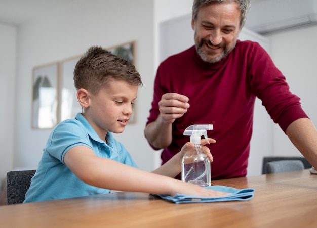 Middellange geschoten man die de tafel van het kind aan het kijken is